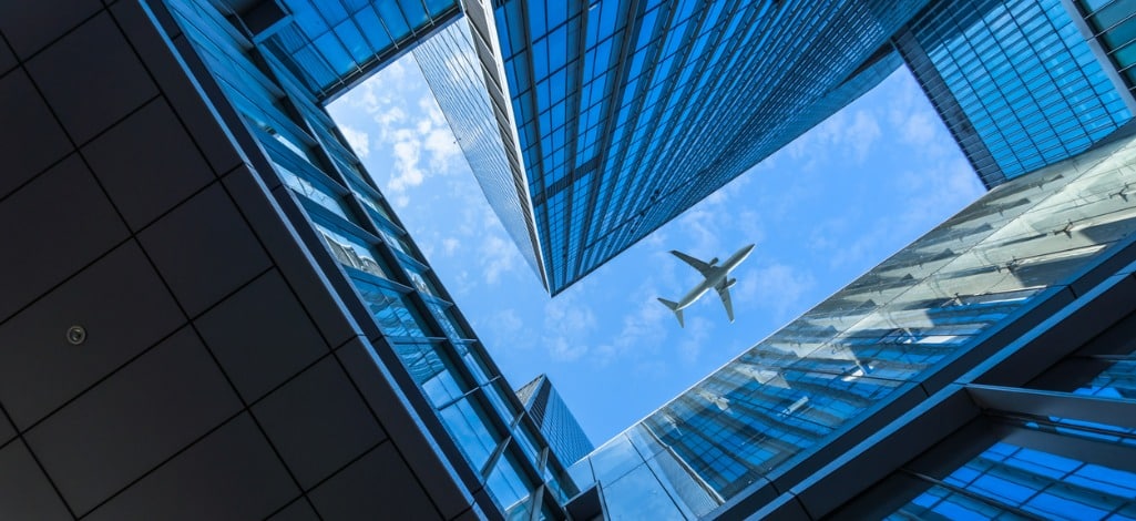 plane flying over skyscrapers