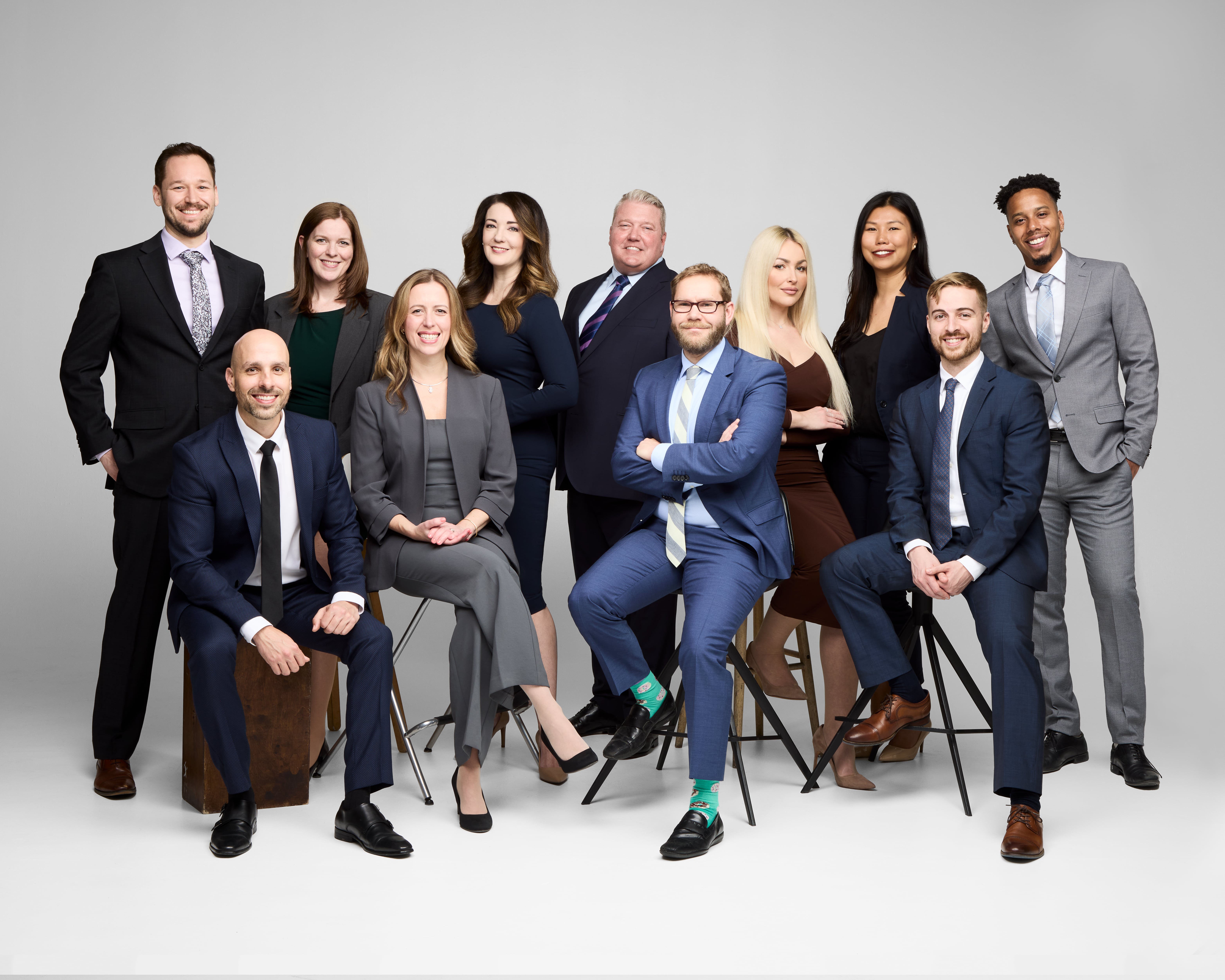 Large group of lawyers pose for a photo in a studio setting.
